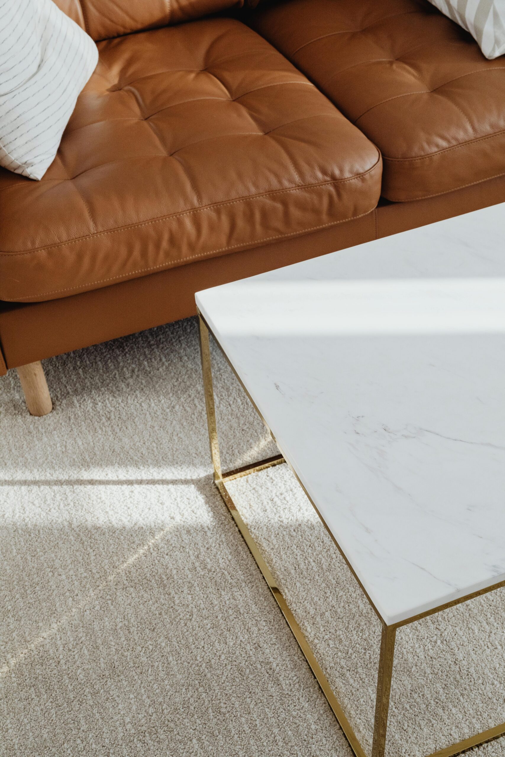 A sleek interior design showcasing a leather sofa and marble table in a living room.